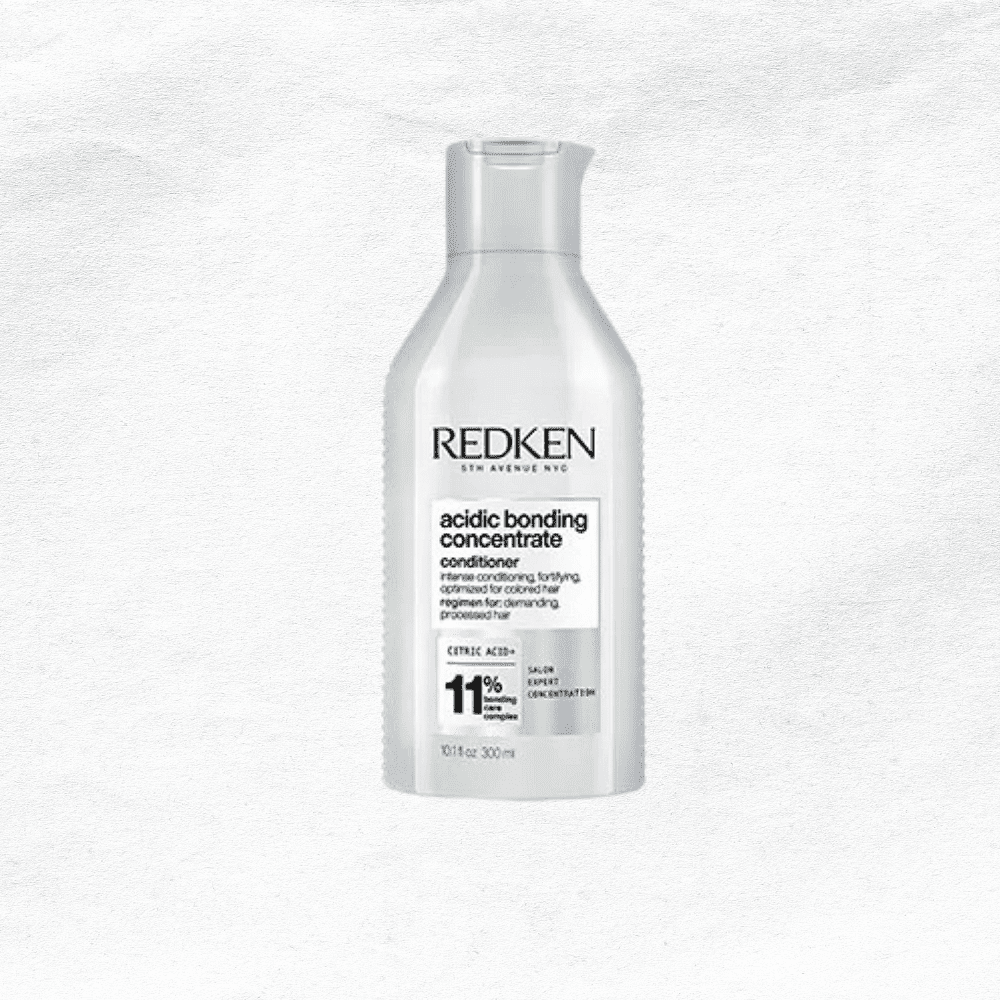 Bottle of Redken Acidic Bonding Concentrate Conditioner against a textured white background.