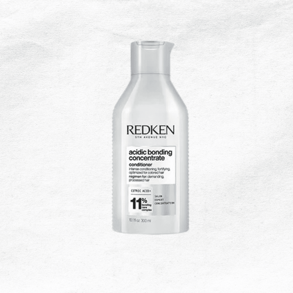 Bottle of Redken Acidic Bonding Concentrate Conditioner against a textured white background.