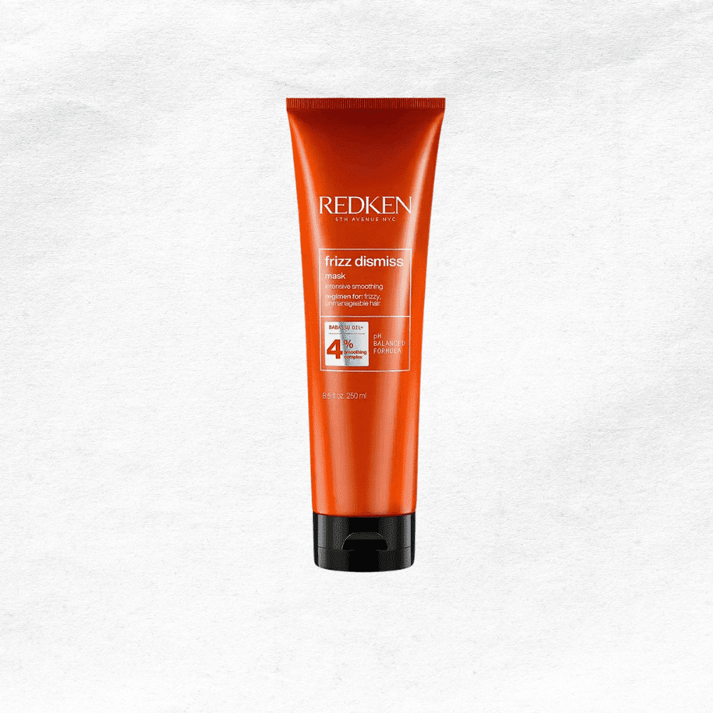 Redken Frizz Dismiss smoothing control cream in an orange tube on a white background.